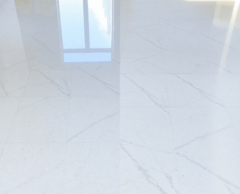 Bright hard floor with one side polished and shiny, the other dull and worn, lit by soft natural light highlighting the texture.