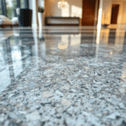 Close-up of a polished granite floor with natural patterns and soft light reflections, highlighting its smooth, glossy surface in a modern home int...