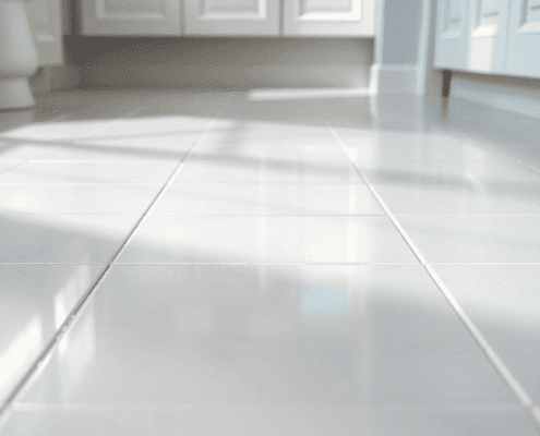 Close-up of clean, shiny ceramic and porcelain tiles with bright white grout lines in a well-lit bathroom or kitchen floor.