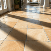 Close-up of elegant flagstone flooring with natural earthy tones and textures, illuminated by sunlight in a bright, modern home setting.