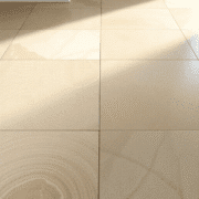 Close-up of elegant limestone floor tiles with natural color variations and fossil patterns, softly lit to highlight texture and timeless beauty.