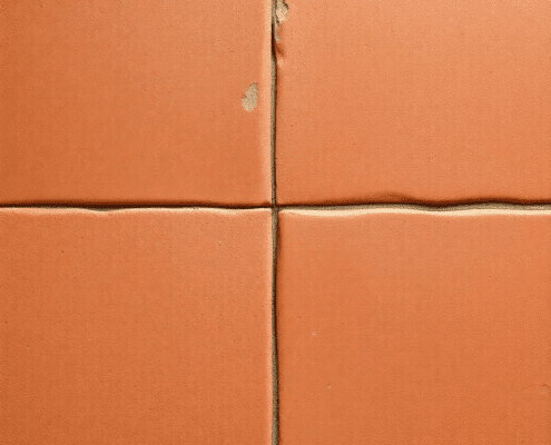 Close-up of warm terracotta floor tiles with natural textures and earthy reddish-brown tones, softly lit to showcase their porous, handcrafted surf...