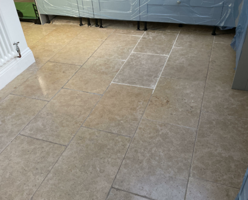 Limestone kitchen floor before cleaning note 2 new tiles installed by client requesting a match to original floor in Yoxhall, Staffordshire